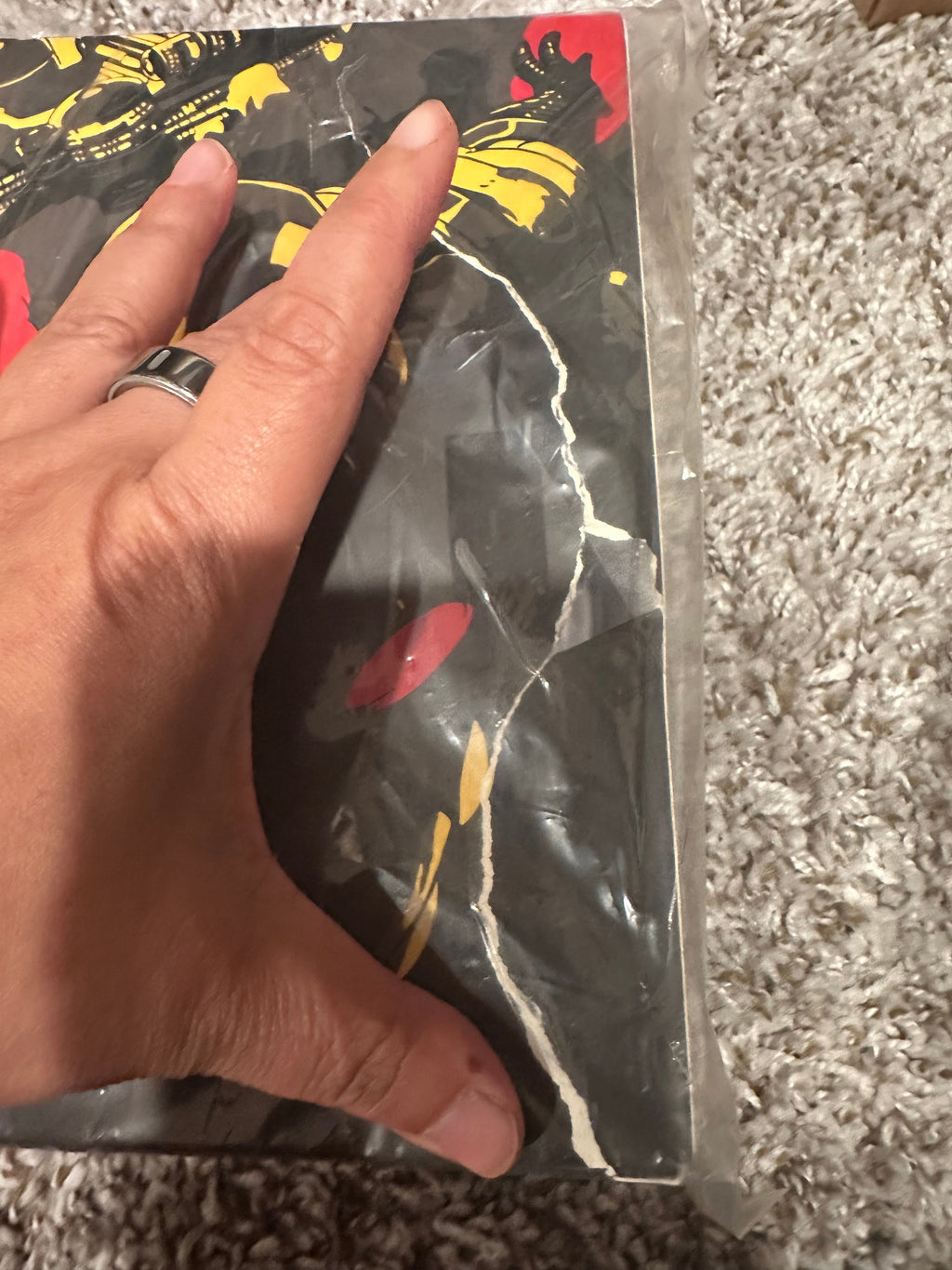 Hand holding a transparent bag with a design on a textured surface